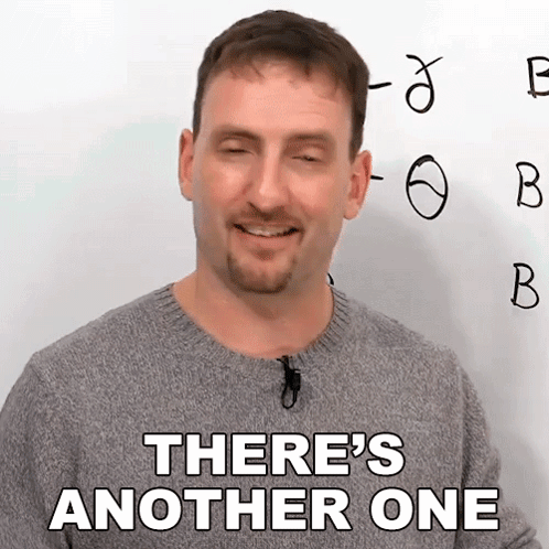 A Man In A Grey Sweater Says There 'S Another One In Front Of A White Board GIF