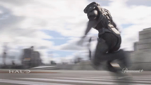 A Man In A Halo Costume Is Running On A Road GIF