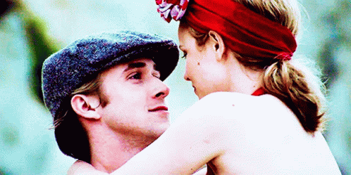 A Man In A Hat And A Woman In A Red Headband Are Hugging GIF