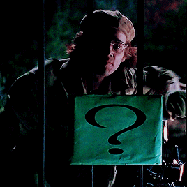 A Man In A Hat Holds A Green Sign With A Question Mark On It GIF