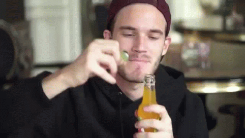 A Man In A Hat Is Drinking From A Bottle Of Beer . GIF