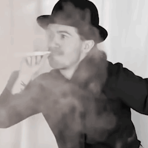 A Man In A Hat Is Drinking From A Cup With Smoke Coming Out Of His Mouth . GIF