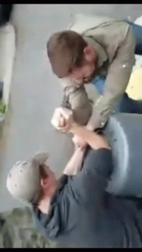 Man In Hat Holding Another's Arm GIF
