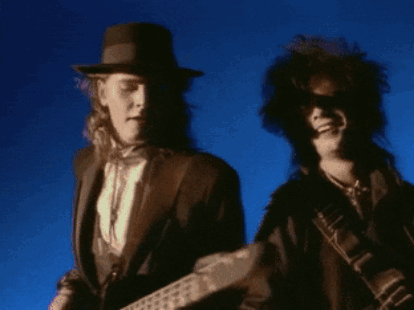 Man In Hat Playing Guitar Next To Man In Sunglasses GIF