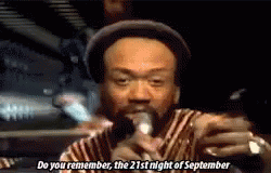 a man in a hat is singing into a microphone and saying do you remember the 21st night of september .