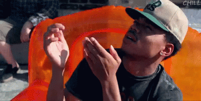 A Man In A Hat Is Sitting On An Orange Raft GIF