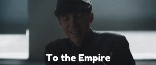 A Man In A Hat Is Smiling And The Words To The Empire Are Behind Him GIF