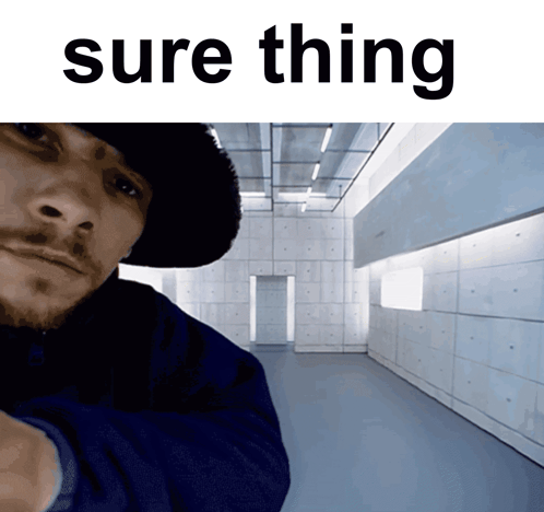 A Man In A Hat Is Standing In A Hallway With The Words Sure Thing Above Him GIF