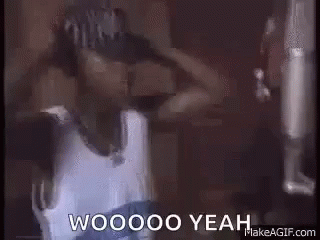 A Man In A Hat Is Standing In Front Of A Microphone And Says Woooo Yeah . GIF