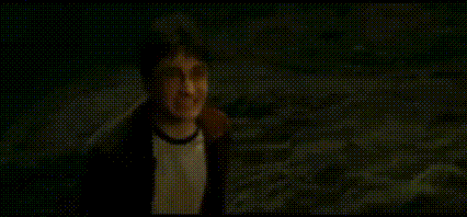 A Man In A Hat Is Standing In The Dark And Saying `` Coward '' . GIF