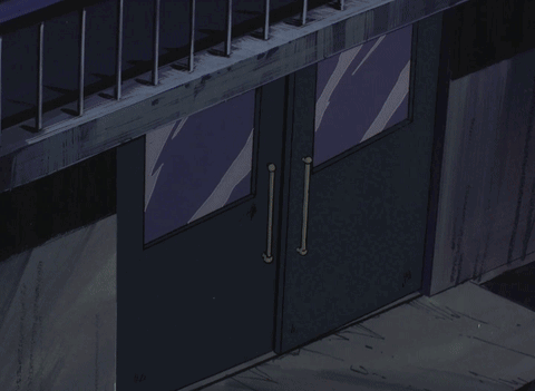 A Man In A Hat Stands In A Doorway GIF