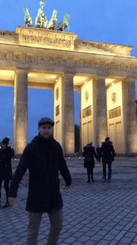Man In Hat In Front Of Columned Building GIF