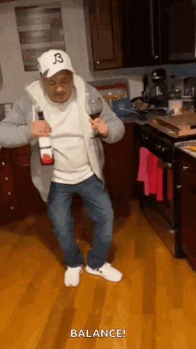 A Man In A Hat With The Letter B On It Is Holding A Bottle Of Wine And A Glass . GIF
