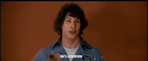 A Man In A Hawaiian Shirt Is Holding A Piece Of Bubble Wrap In A Room With Other Men GIF