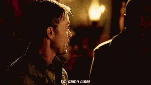 A Man In A Hawaiian Shirt Is Talking To Another Man In A Dark Room . GIF
