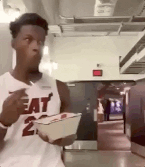A Man In A Heat Jersey Is Eating A Meal From A Bowl . GIF
