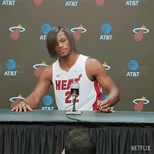 A Man In A Heat Jersey Is Sitting At A Table GIF