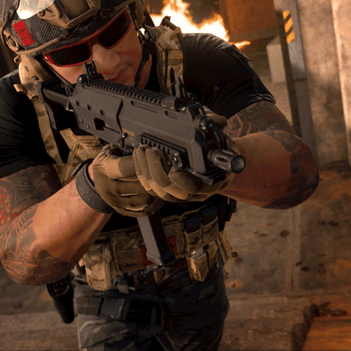 A Man In A Helmet And Sunglasses Holds A Gun GIF