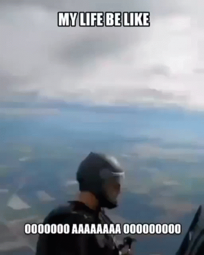 a man in a helmet is flying a parachute in the air .