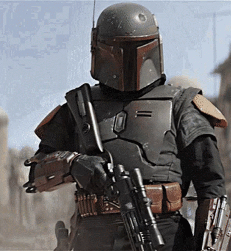 A Man In A Helmet Is Holding A Gun In His Hand GIF