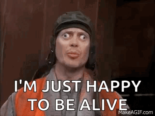 A Man In A Helmet Is Making A Funny Face And Says `` I 'M Just Happy To Be Alive '' . GIF