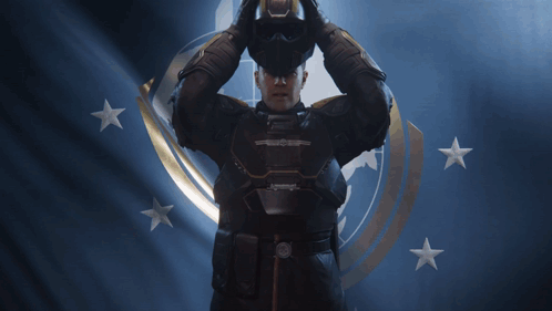 A Man In A Helmet Is Standing In Front Of A Flag With Stars GIF