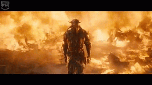 Man In Helmet Standing In Front Of Fire GIF