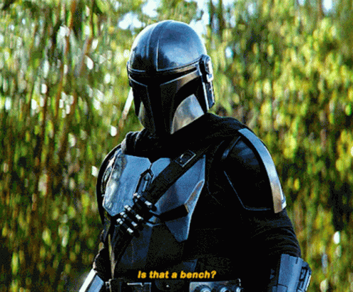 A Man In A Helmet Stands In Front Of Trees And Says Is That A Bench GIF