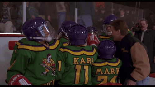 A Man In A Hockey Helmet Is Talking To Another Man And The Words Mac Mac Are Visible GIF
