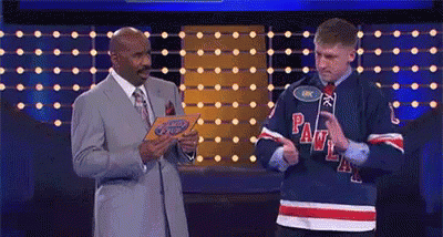A Man In A Hockey Jersey Is Standing Next To A Man In A Suit And Tie On A Stage . GIF