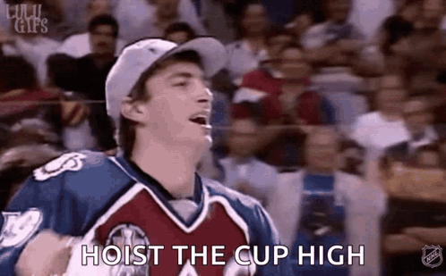 A Man In A Hockey Uniform Is Holding A Hockey Puck In Front Of A Crowd And Says `` Hoist The Cup High '' . GIF