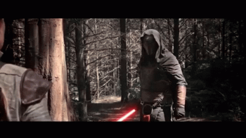 A Man In A Hooded Cape Is Holding A Red Lightsaber GIF