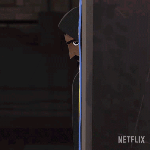 A Man In A Hooded Cape Is Peeking Out From Behind A Wall With A Netflix Logo In The Corner GIF