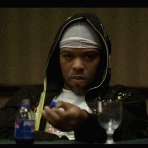 A Man In A Hooded Jacket Is Sitting At A Table With A Pepsi Bottle GIF