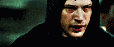 A Man In A Hooded Jacket Is Standing In Front Of A Mirror . GIF