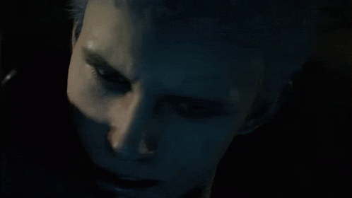 A Man In A Hooded Jacket Looks Down At Something GIF