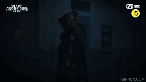 A Man In A Hooded Jacket Stands In Front Of A Sign That Says Do Not Enter GIF