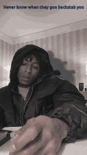 A Man In A Hooded Jacket With The Words Never Know When They Gon Backstab You On The Bottom GIF