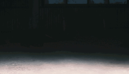A Man In A Hooded Sweatshirt Is Running In The Dark GIF