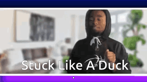 A Man In A Hoodie Is Dancing In A Living Room With The Words `` Stuck Like A Duck '' . GIF