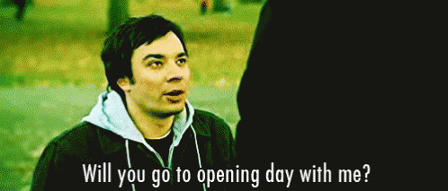 A Man In A Hoodie Is Talking To Another Man In A Park And Asking If He Will Go To Opening Day With Him . GIF