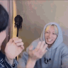 A Man In A Hoodie Is Talking To Another Man In A Room While Another Man Looks On . GIF
