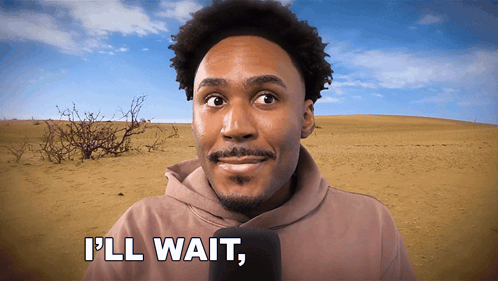 A Man In A Hoodie Says " I 'Ll Wait " In Front Of A Desert GIF