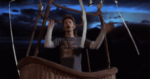 A Man In A Hot Air Balloon Wearing A Shirt That Says ' I 'M A Cowboy ' On It GIF