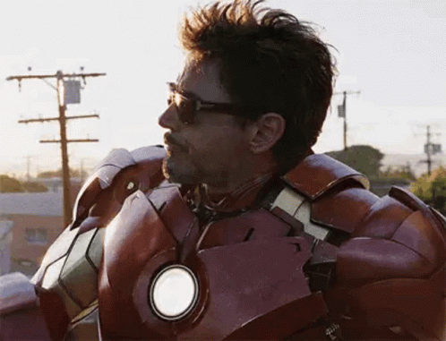 A Man In A Iron Man Suit Is Standing On Top Of A Building . GIF
