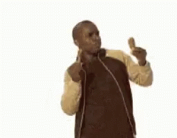 A Man In A Jacket Is Eating A Fried Chicken Wing And Giving A Thumbs Up . GIF