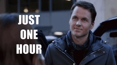 A Man In A Jacket Stands In Front Of A Sign That Says " Just One Hour " GIF