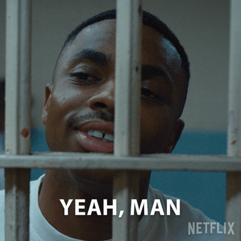 A Man In A Jail Cell Behind Bars With The Words Yeah Man Written Below Him GIF
