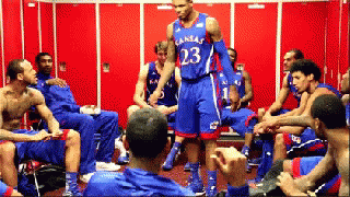 A Man In A Kansas Jersey Stands In A Locker Room With His Teammates GIF