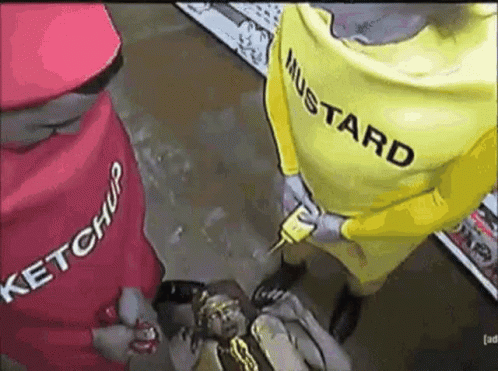 A Man In A Ketchup Costume And A Man In A Mustard Costume Are Holding A Hot Dog . GIF
